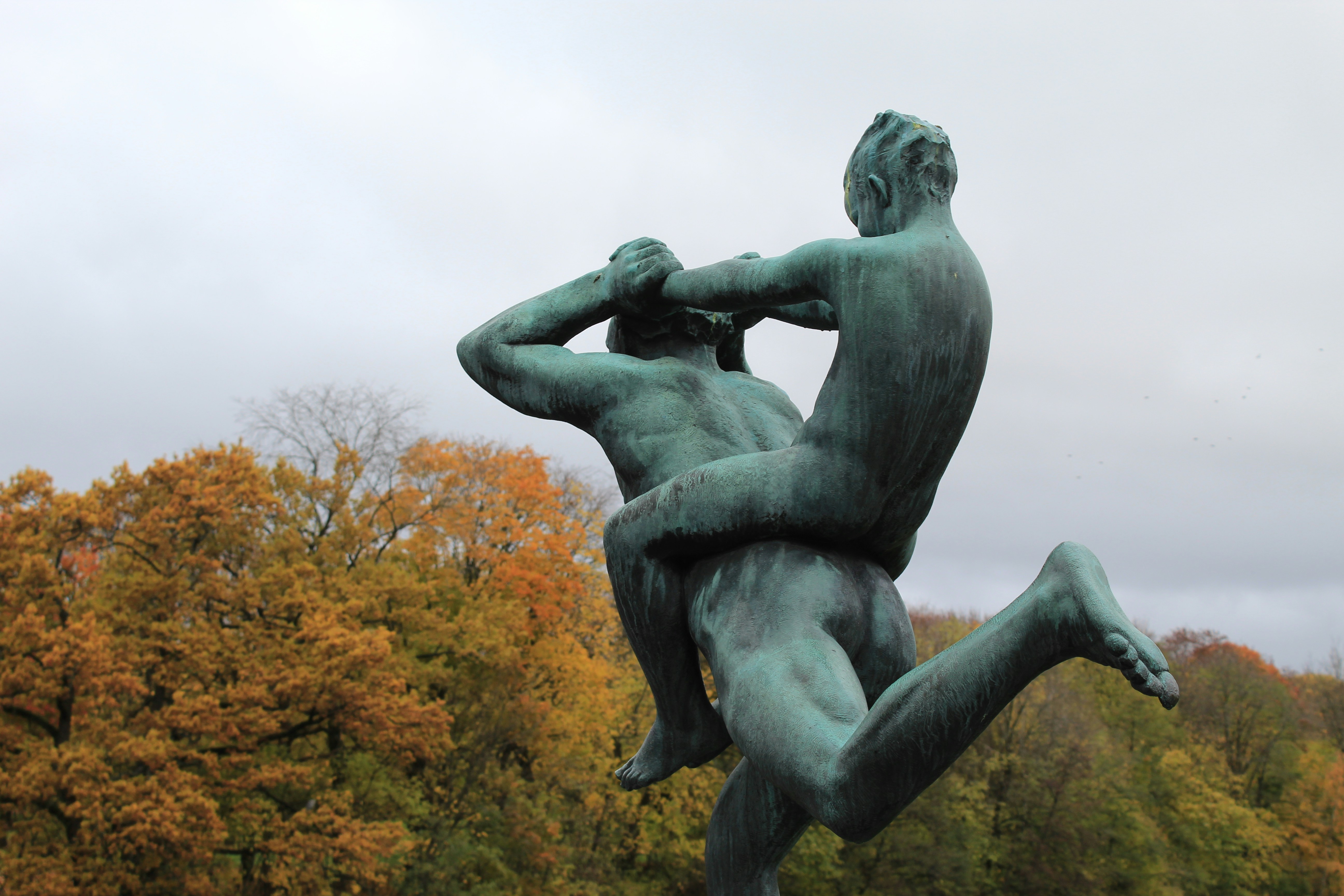 A bronze statue depicts two men wrestling.