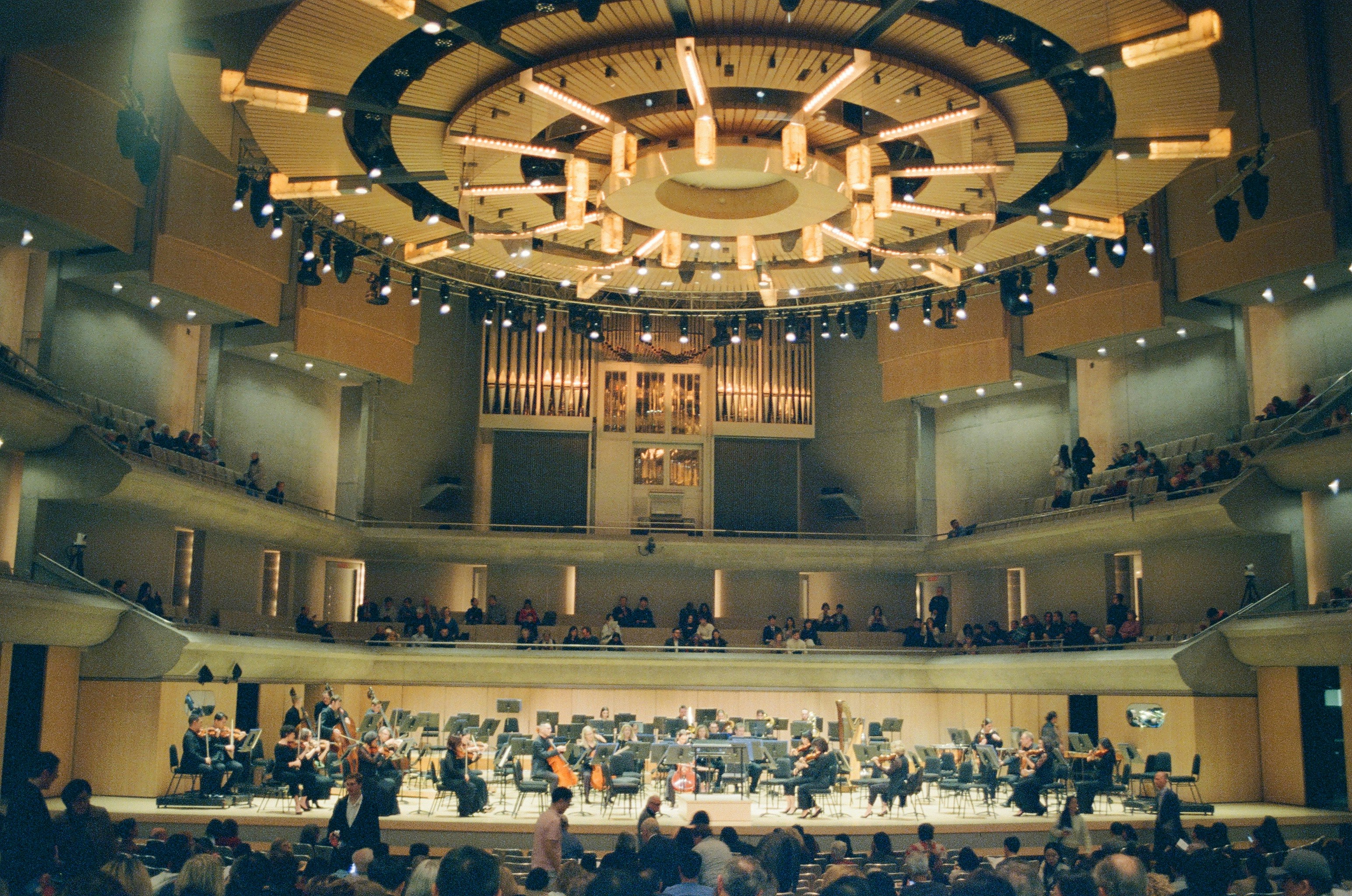 A symphony orchestra performs in a grand concert hall.