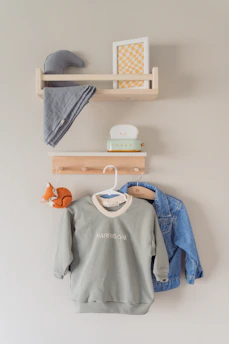 A children's room decorates with clothing and shelves.