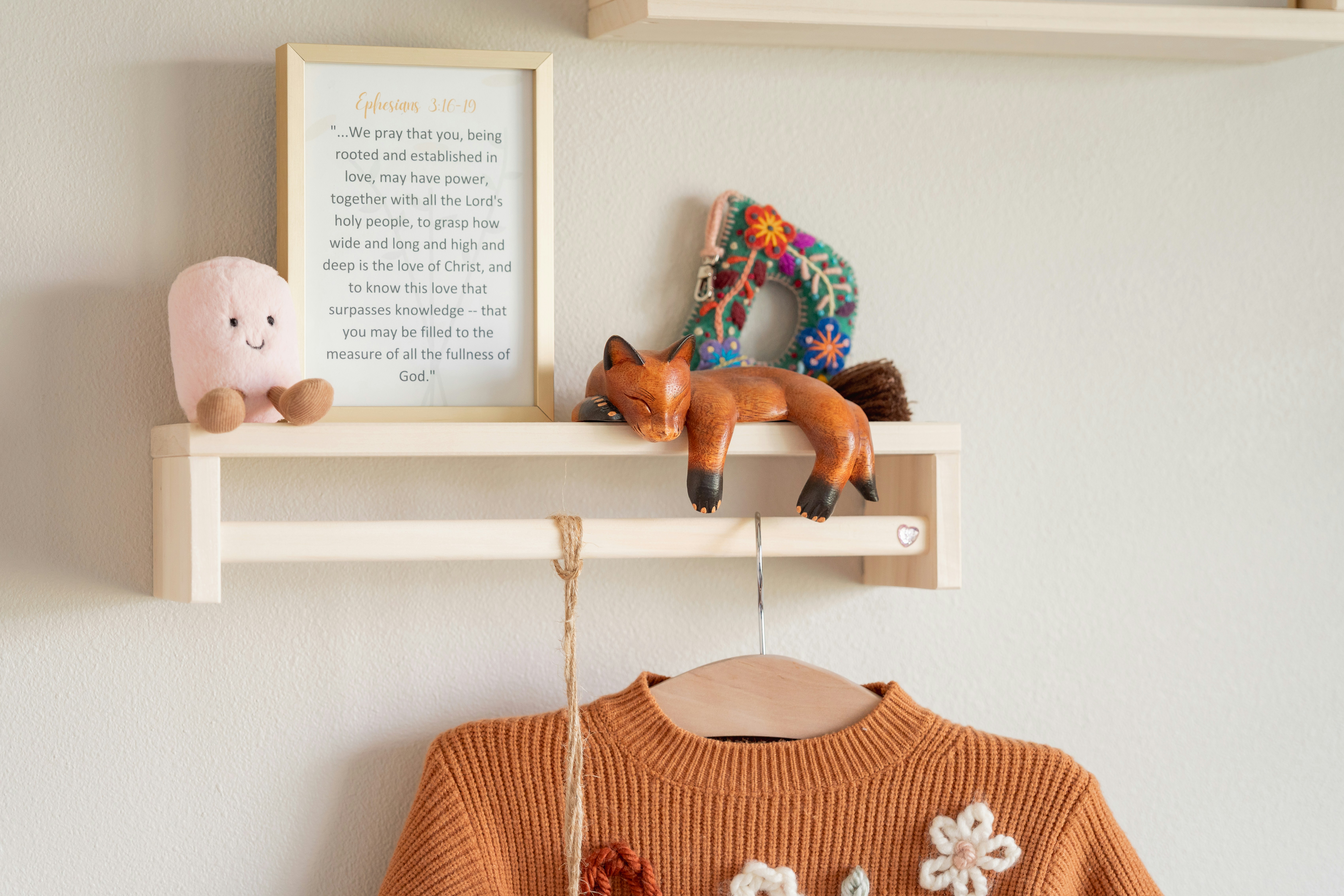 A shelf displays decorations and a cozy sweater.