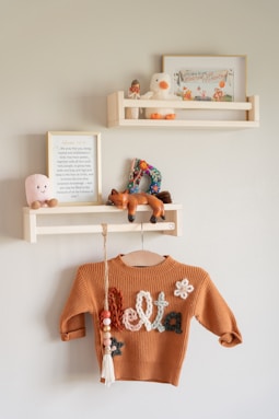 Cozy nursery decor with shelves and a sweater.
