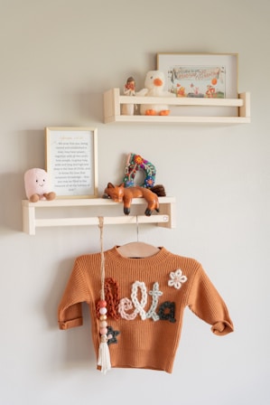 Cozy nursery decor with shelves and a sweater.