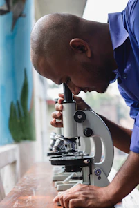 Man uses a microscope to examine something closely.
