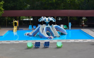 Pool with slides and lounge chairs is shown.