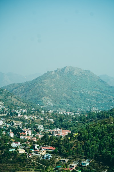A scenic view of a town nestled by a mountain.