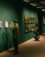People are taking photos of art at a gallery.