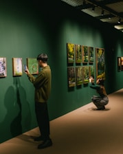 People are taking photos of art at a gallery.