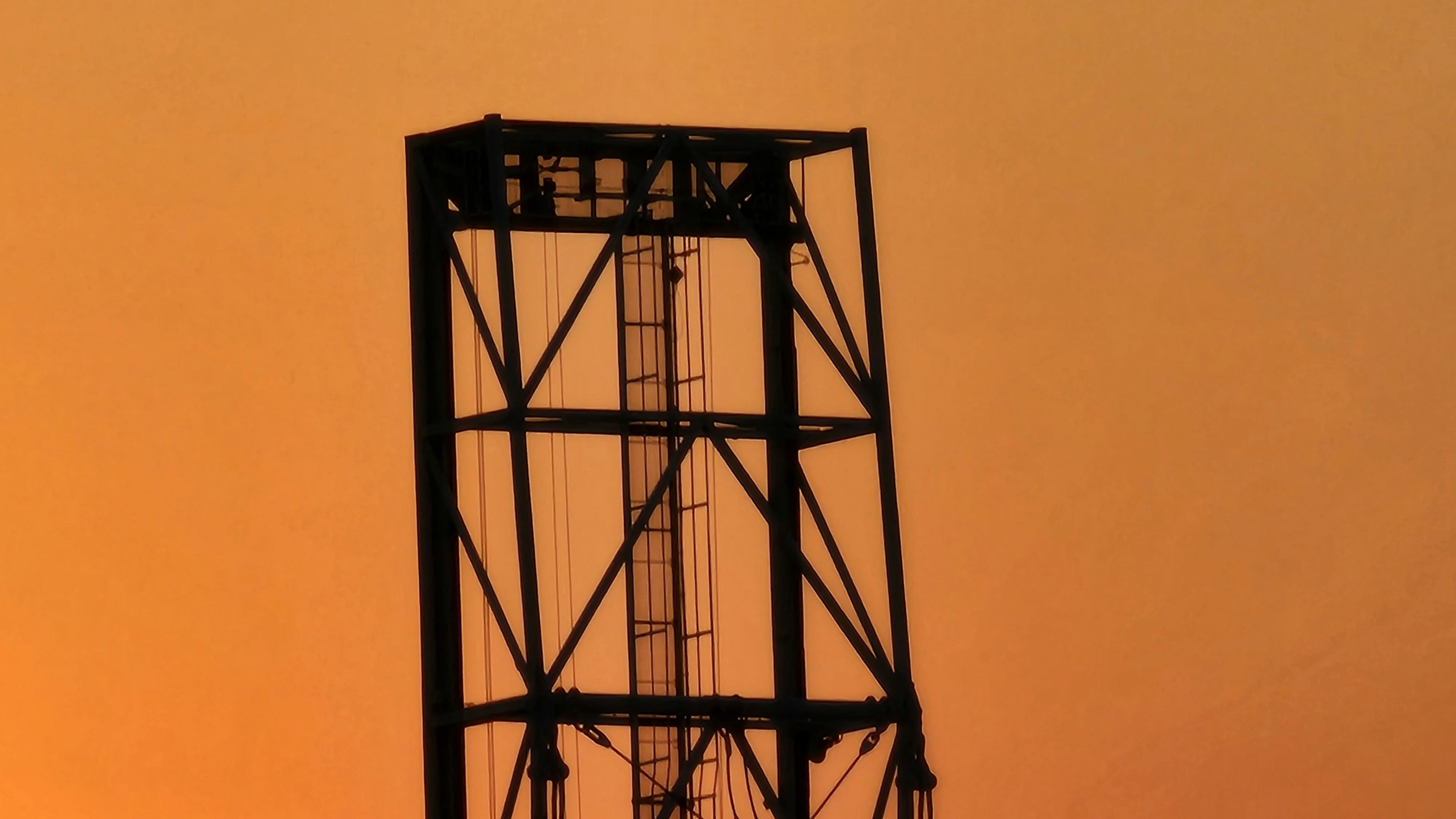 オレンジ色の空を背景にした塔のシルエット。