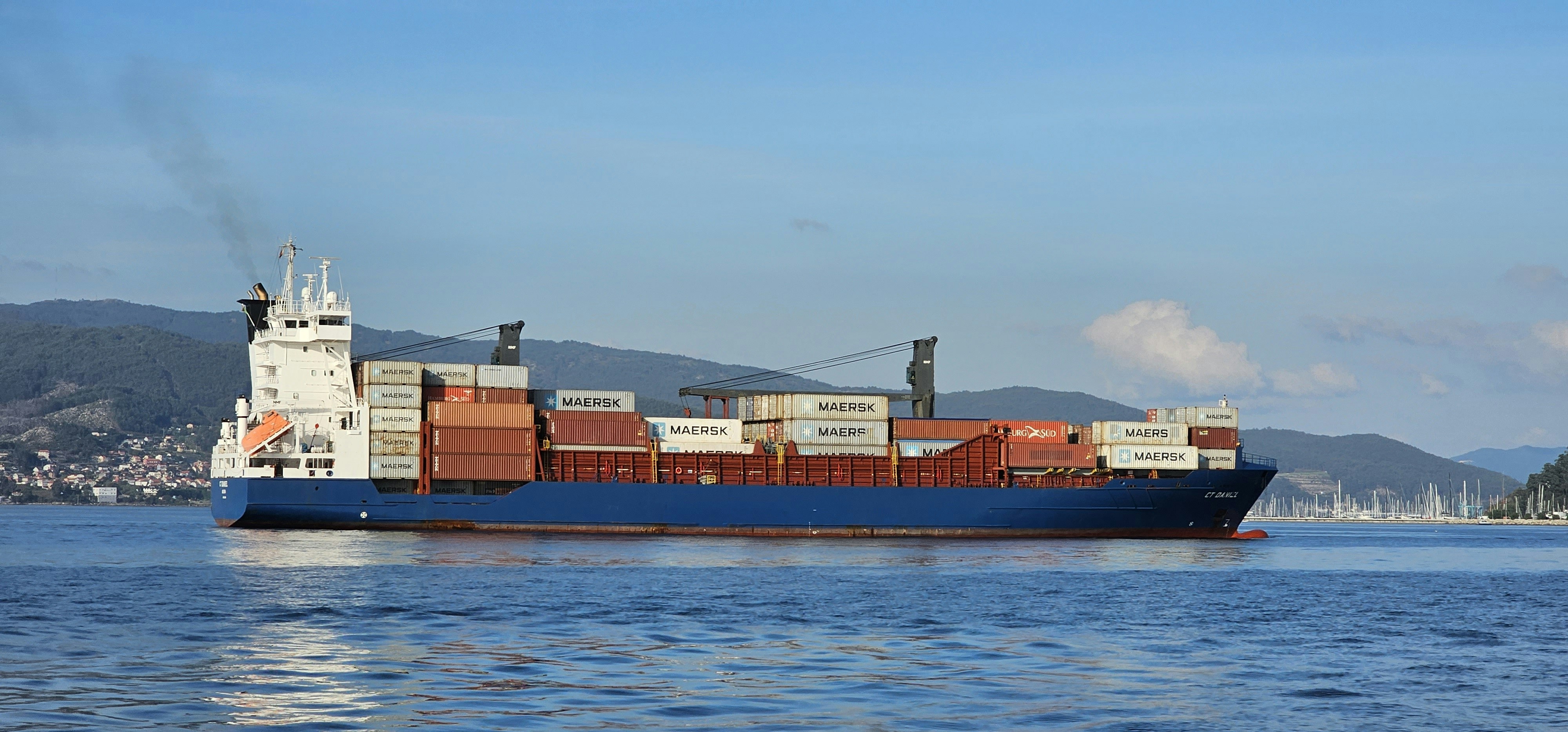 青い海を航行する貨物船。