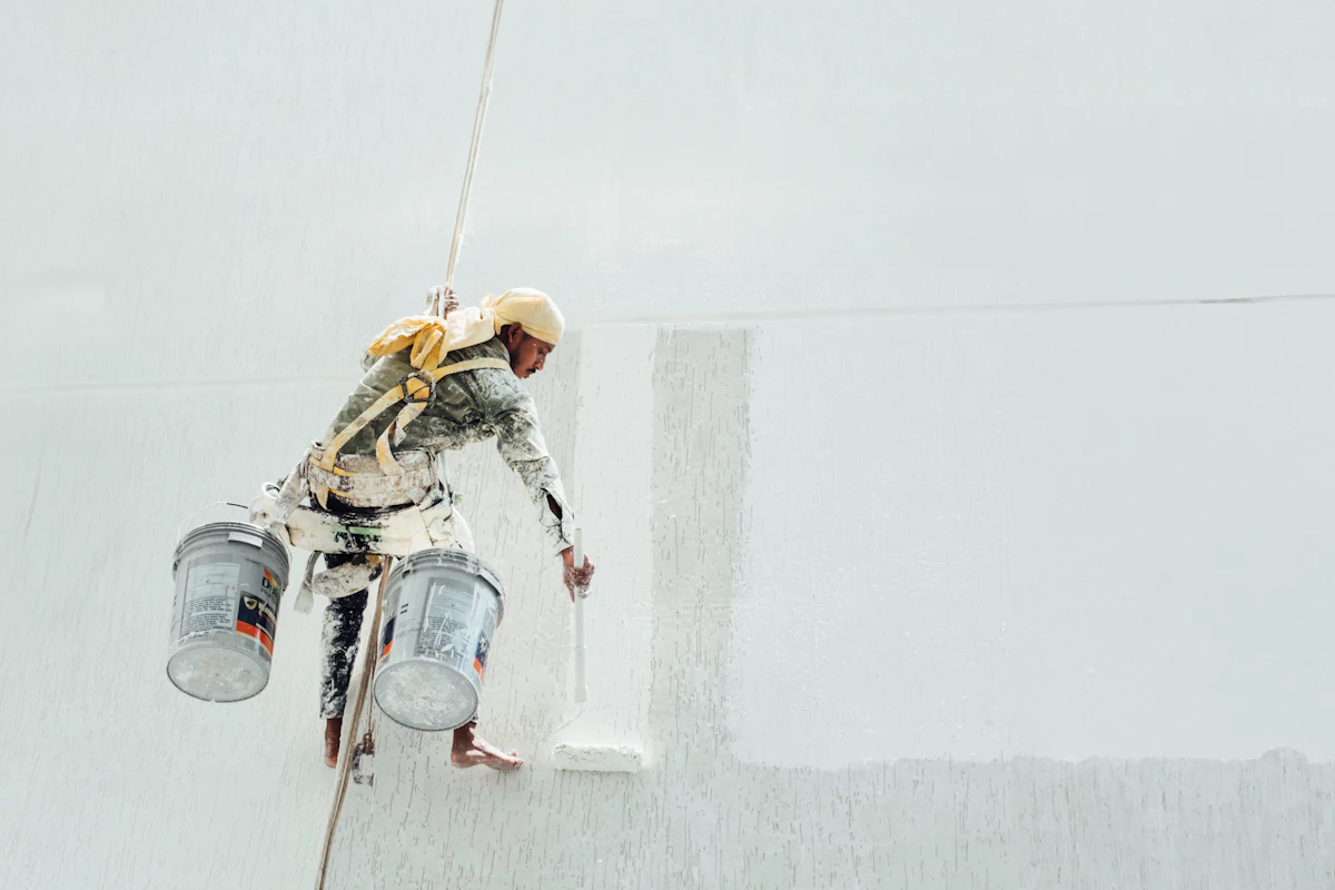 Rope-access painter coating an external wall