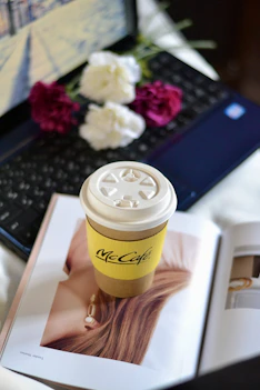 Coffee, flowers, and laptop compose a cozy scene.
