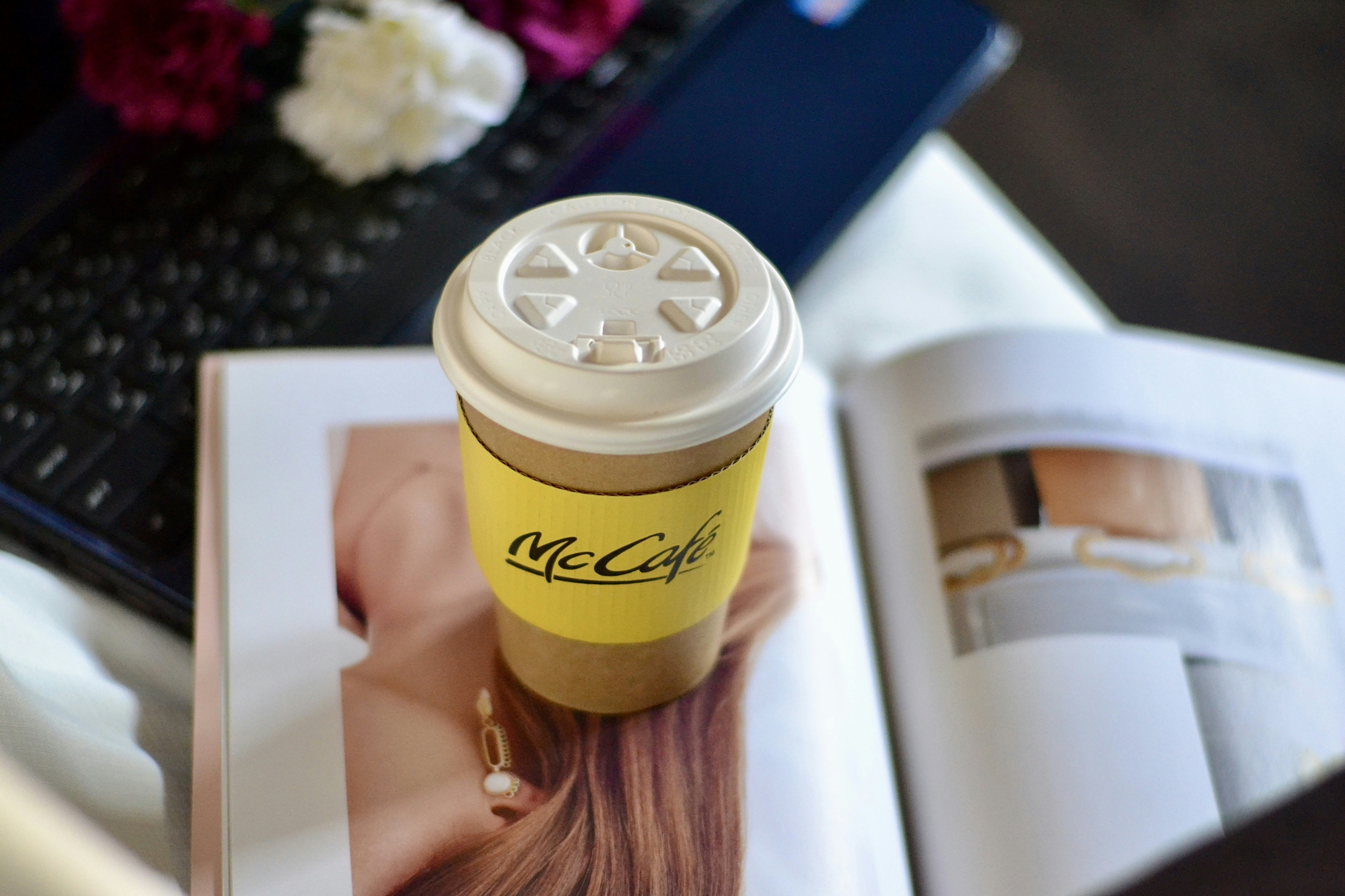 他のアイテムと一緒に雑誌の上のコーヒーカップ。