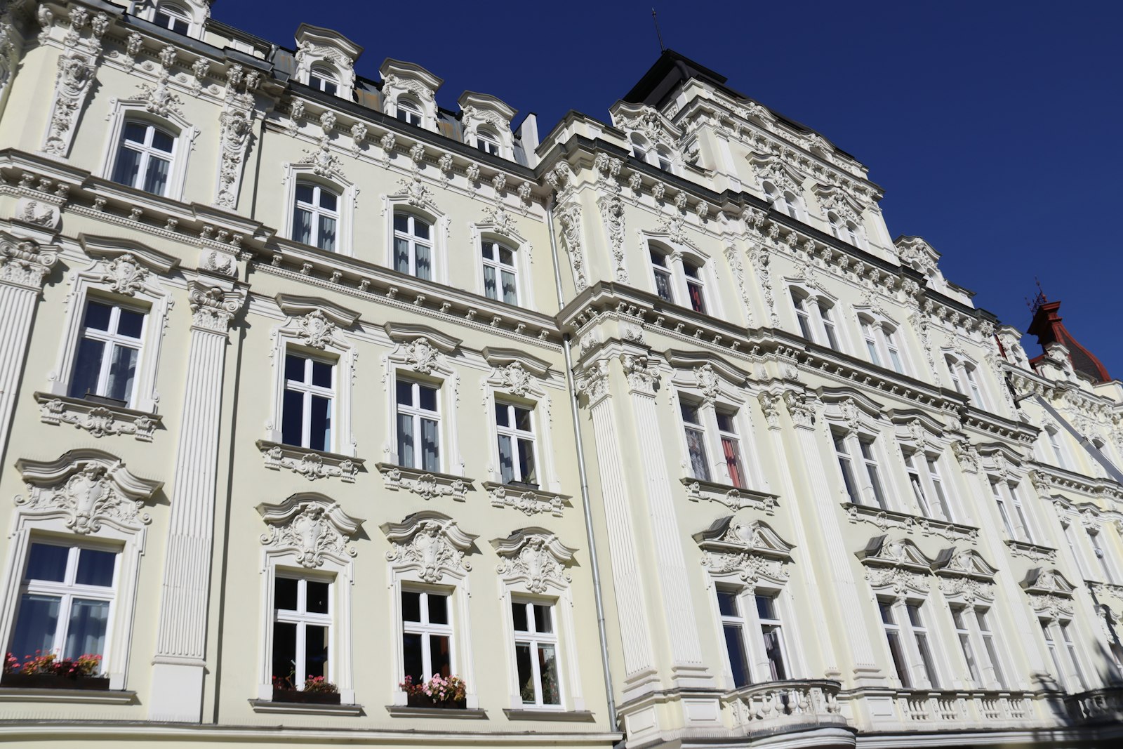 Ornate historic facade with decorative windows under a clear blue sky in Karlovy Vary
