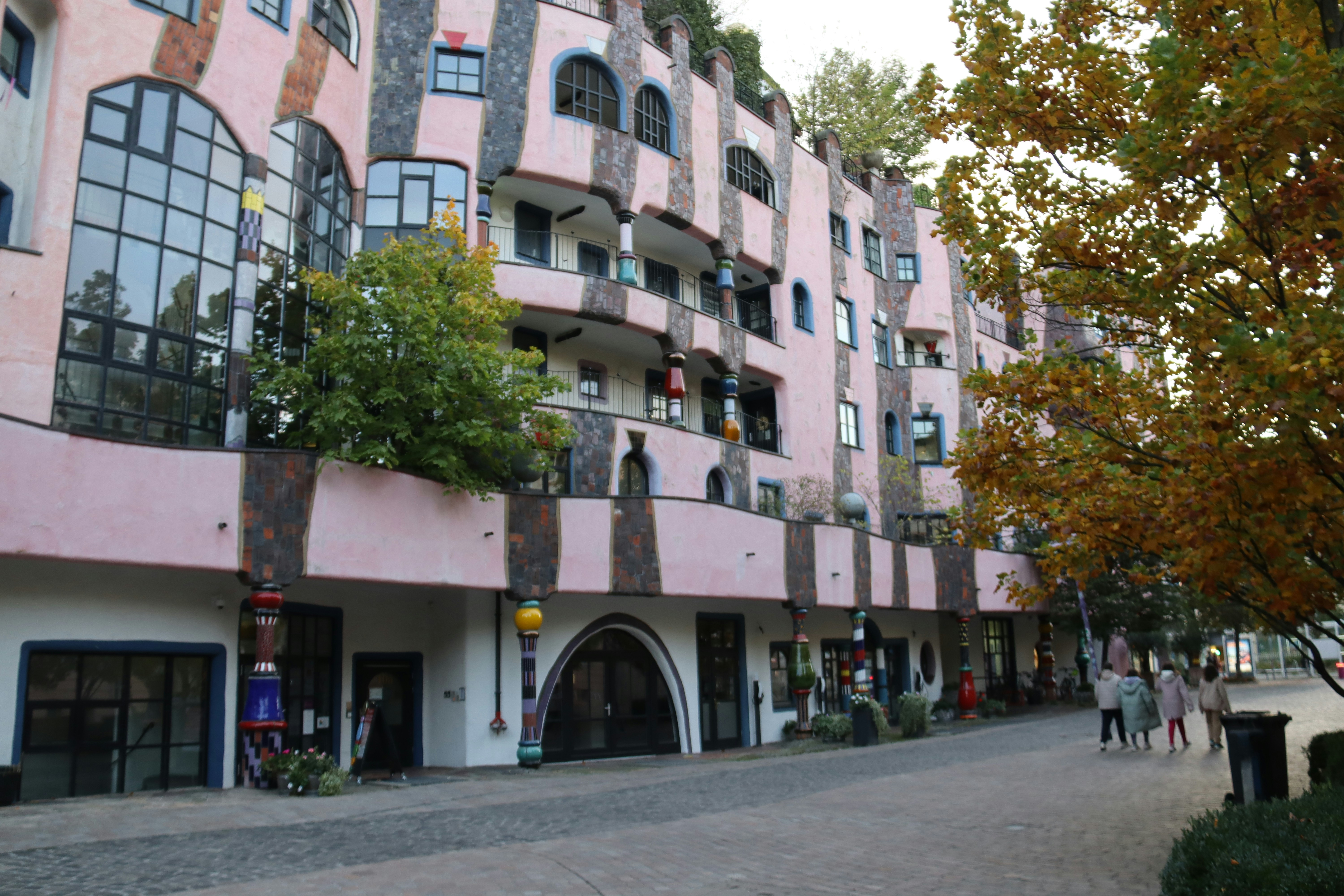Un edificio colorido e inusual se encuentra junto a una pasarela.