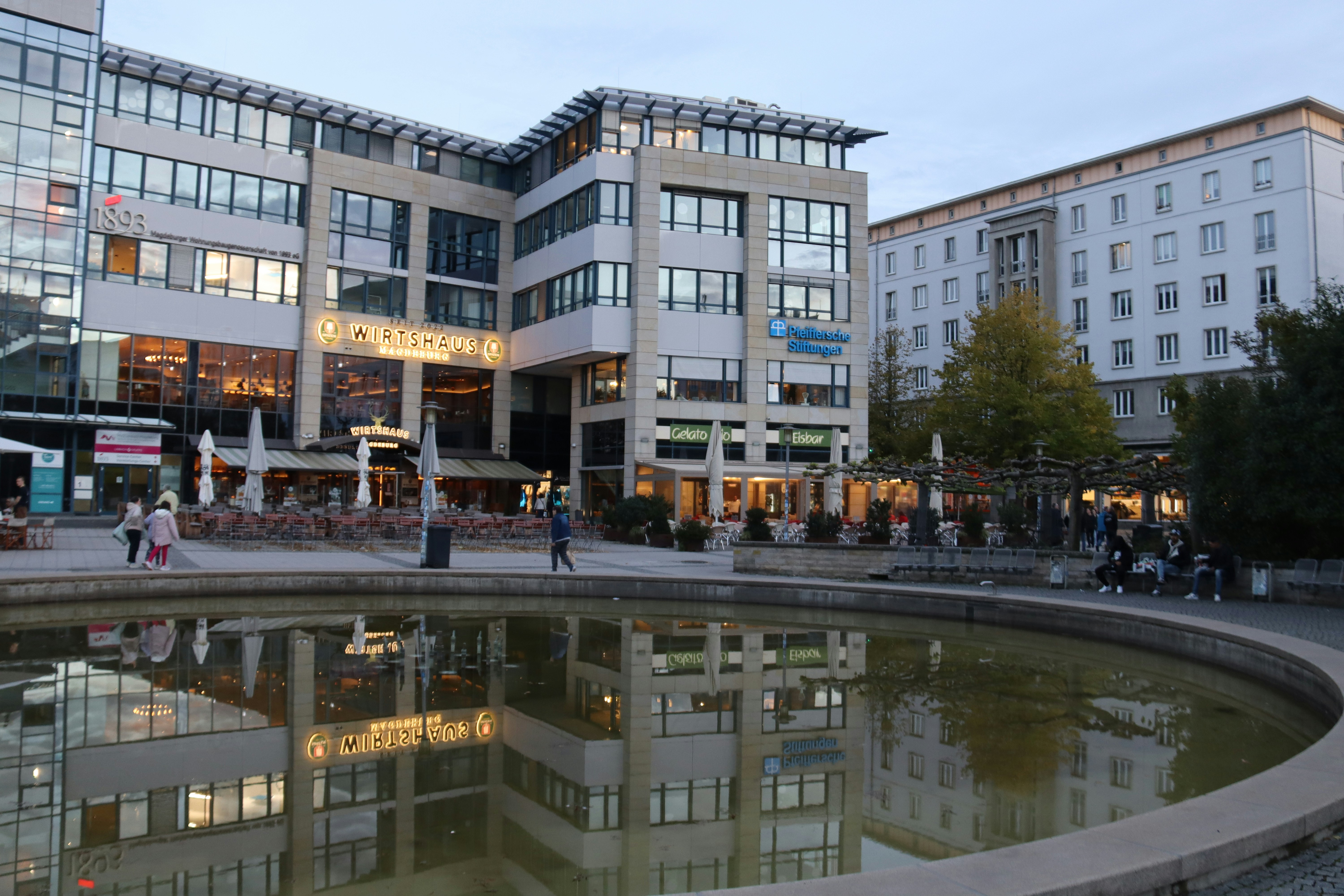 A modern building stands beside a fountain.