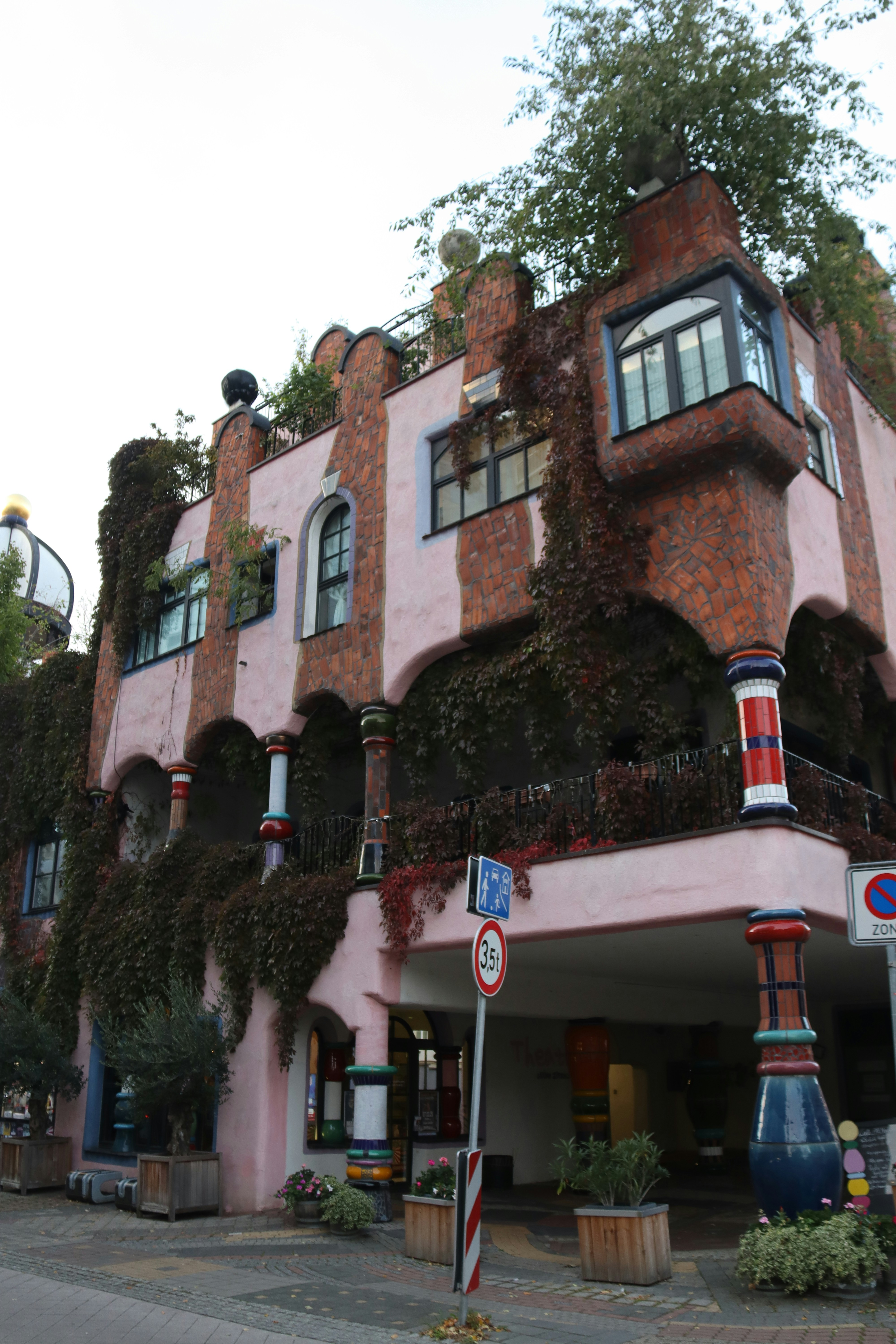 A unique, colorful building with foliage.
