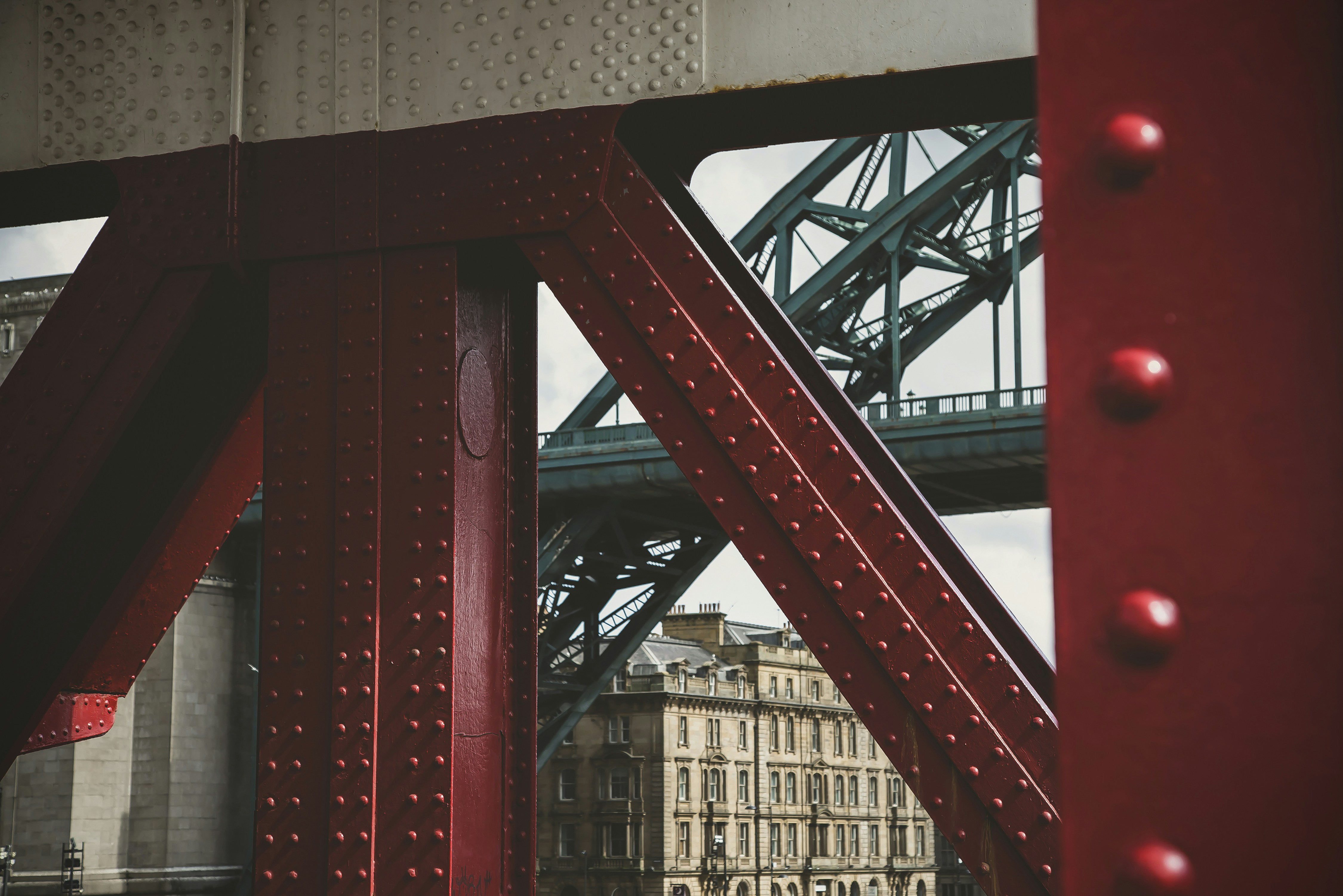 Red bridge structure with background buildings and bridge.