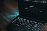 A laptop displays a search bar asking how it can help.