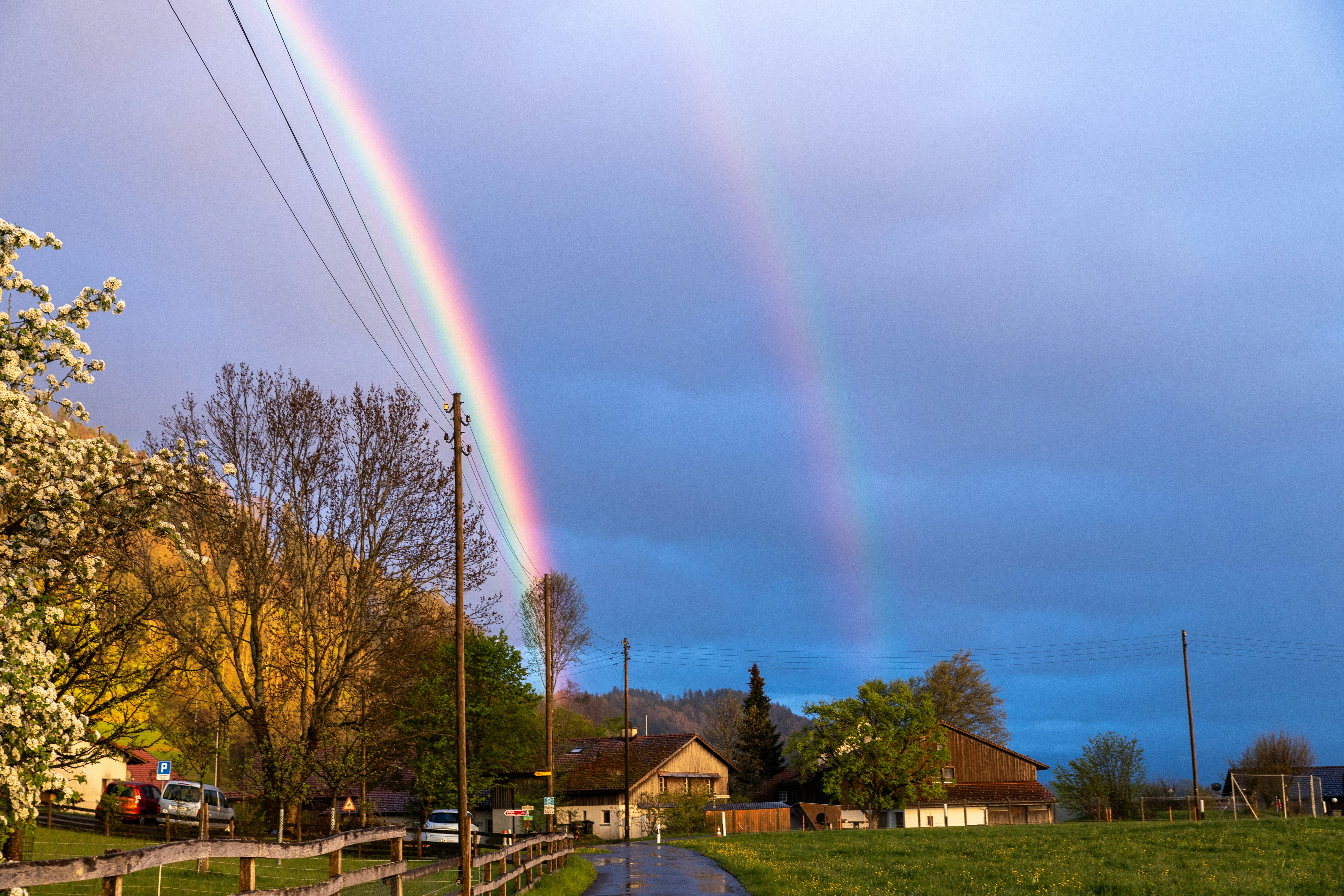 A beautiful double rainbow arches over a landscape.