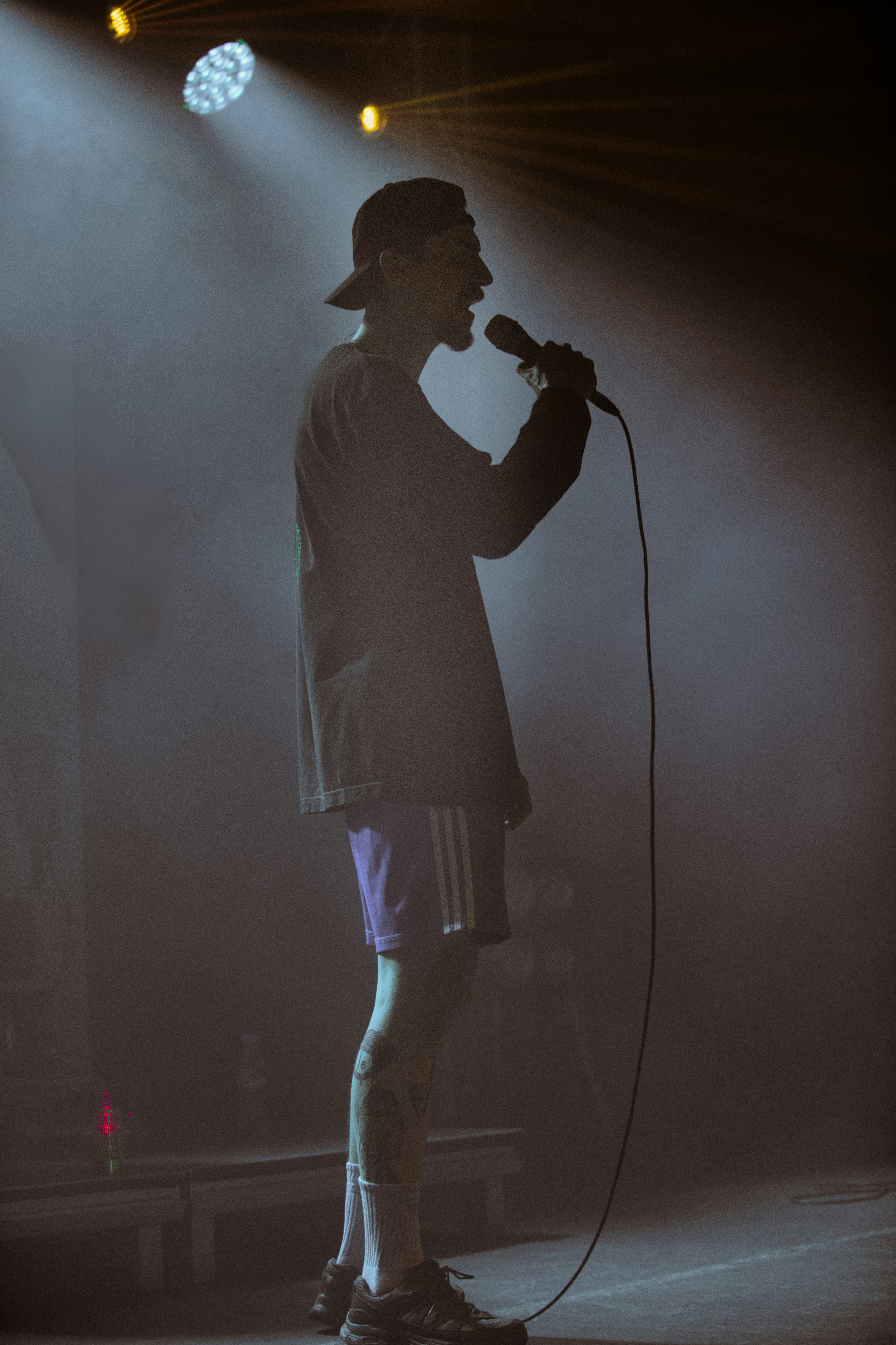 A singer performs under stage lights.