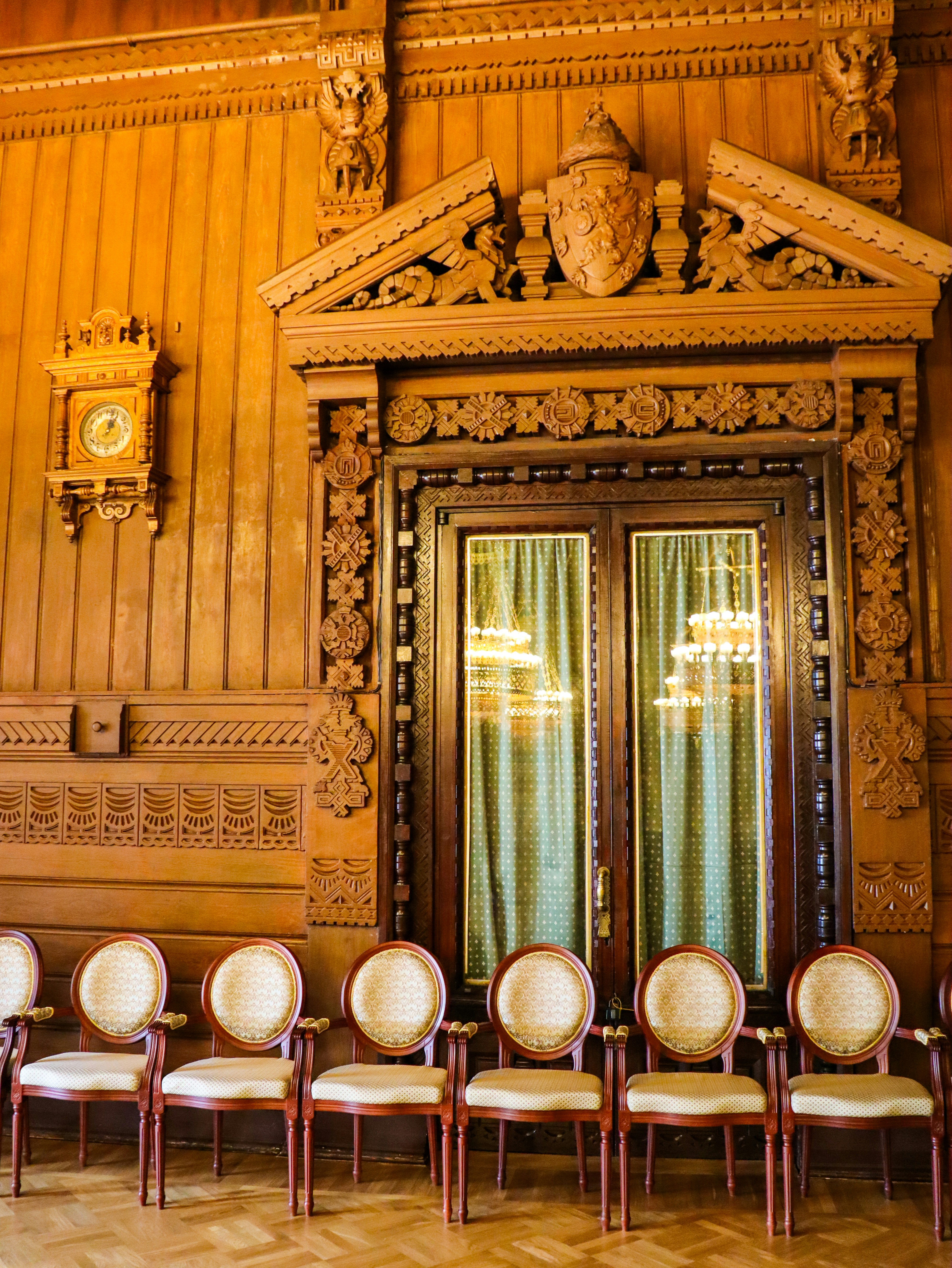 Ornate, wooden interior with beautiful detailing and chairs.