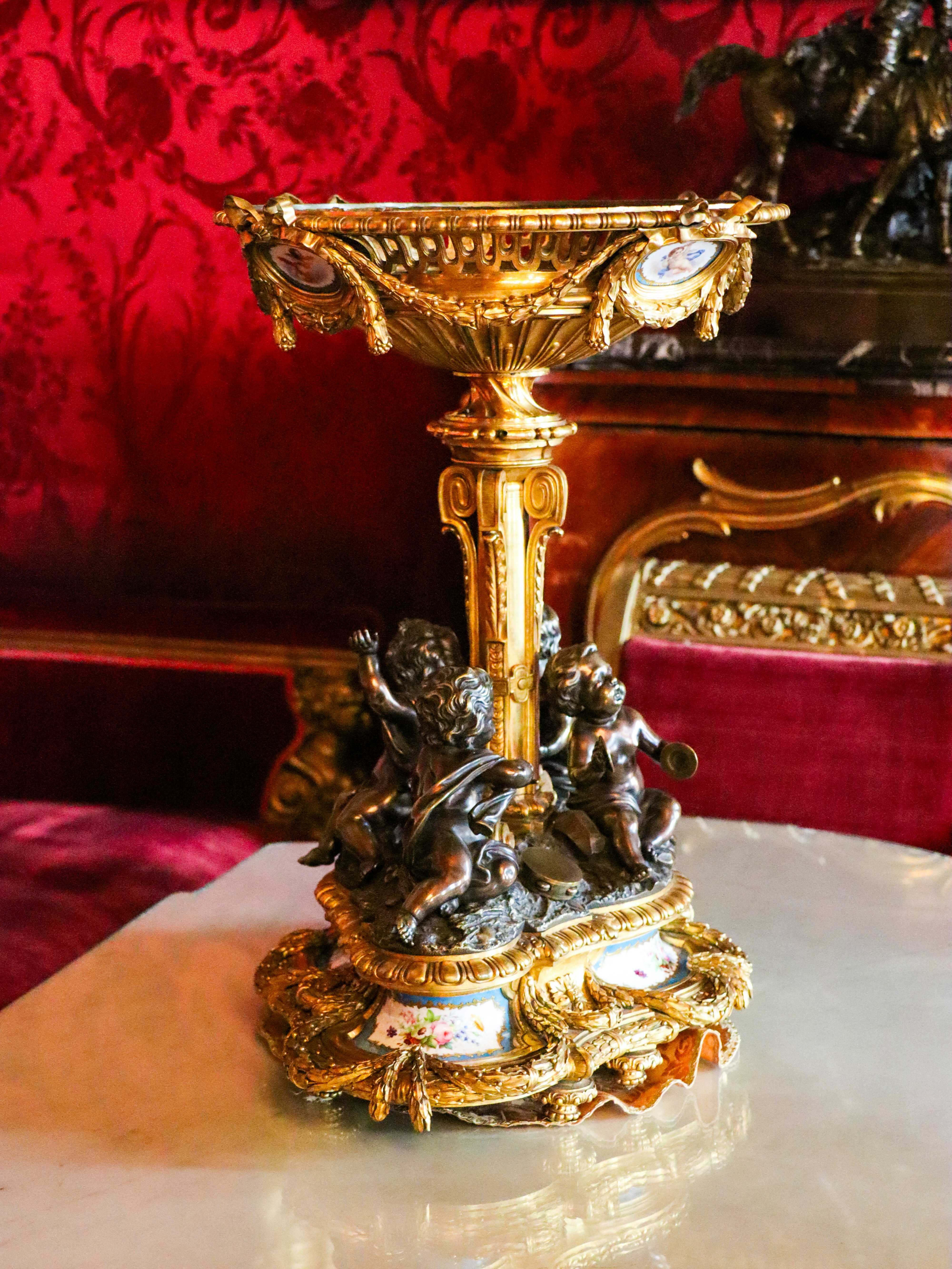 Ornate gold sculpture of a cherubic fountain.