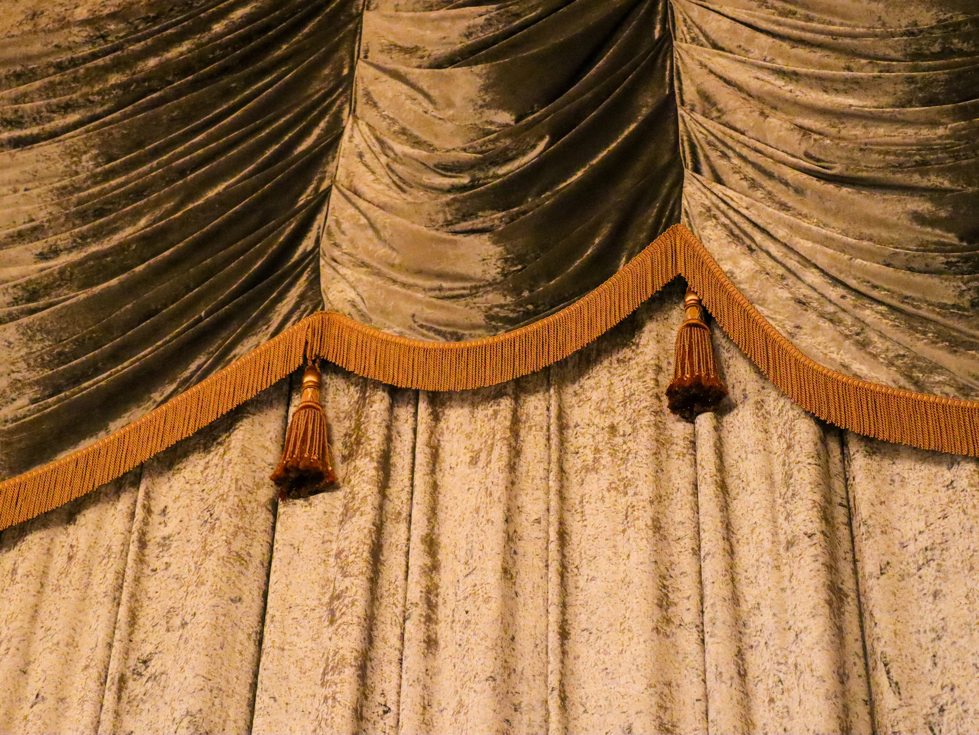 Heavy, textured curtains with decorative trim.