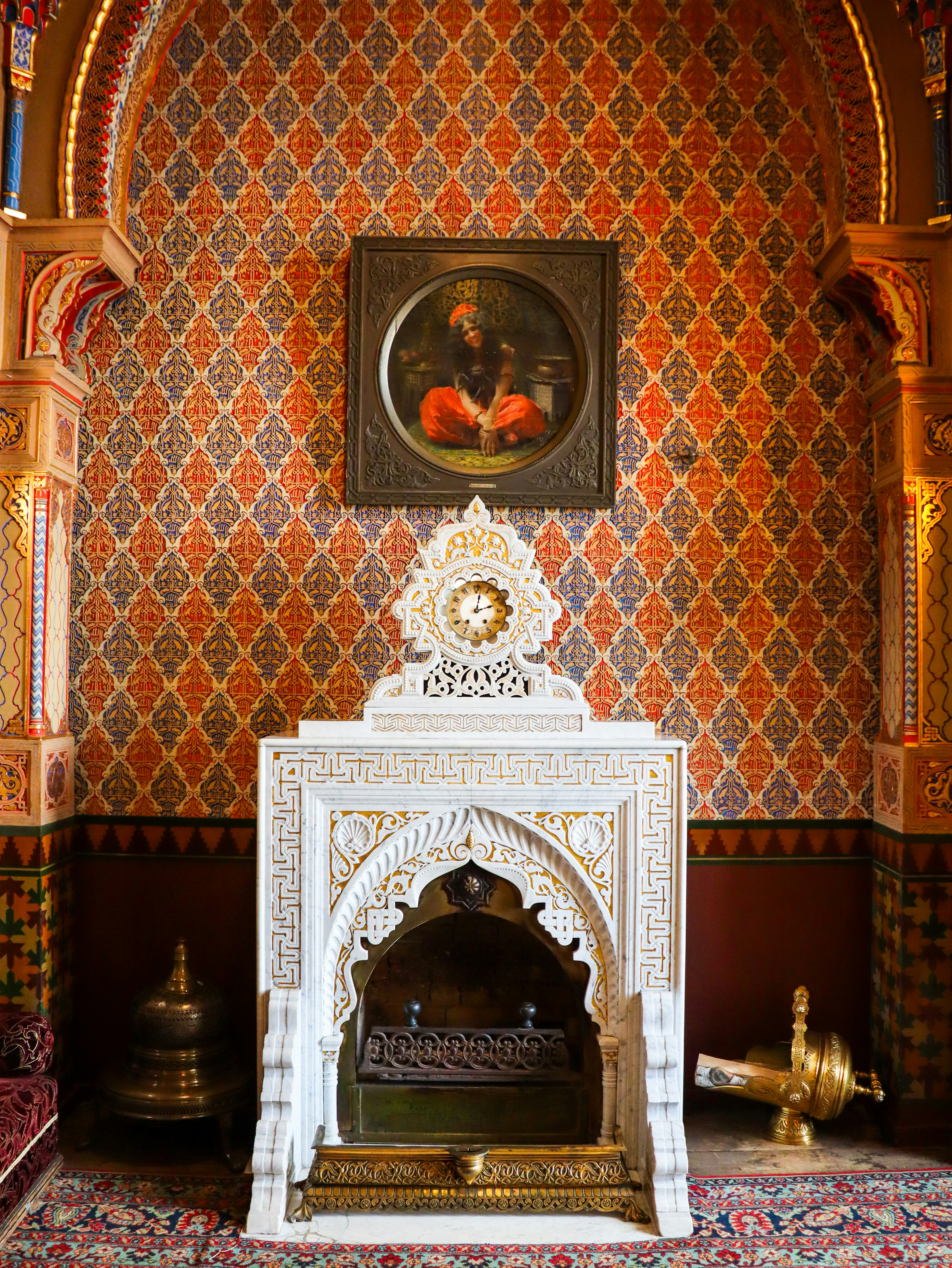 Ornate room features a fireplace and portrait.