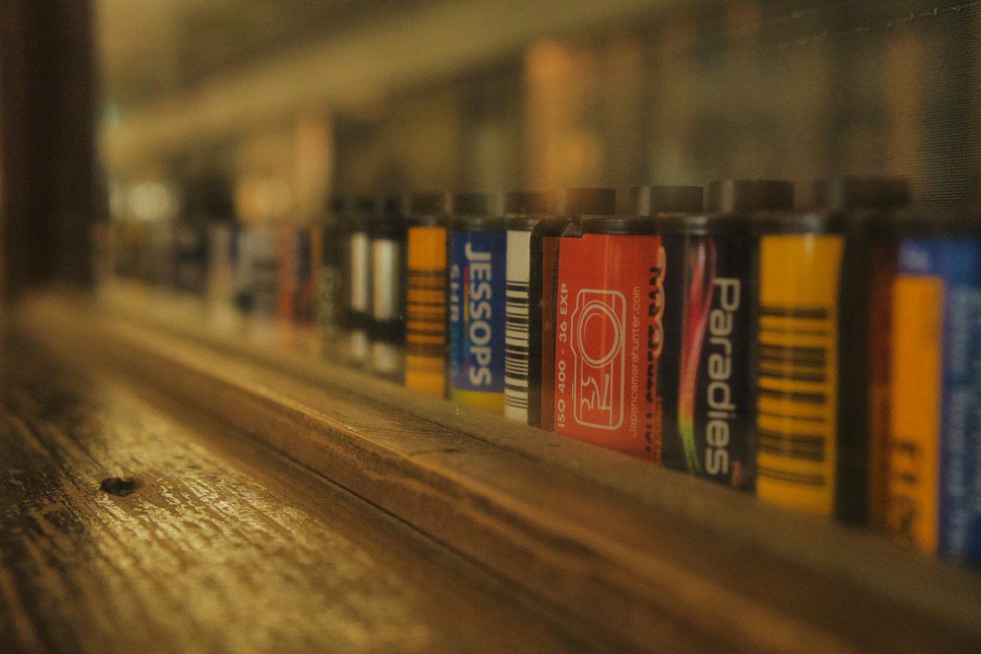 Film rolls are lined up on a shelf.