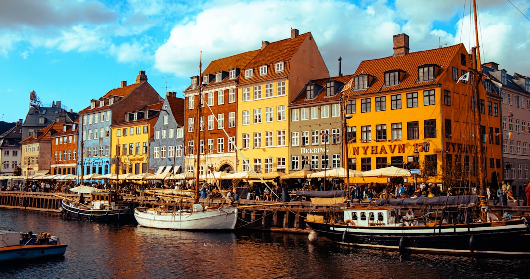 Colorful buildings line a canal with boats in copenhagen., Boats along Nyhavn canal in Copenhagen