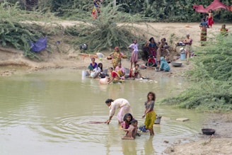 People are washing clothes and bathing in the water.