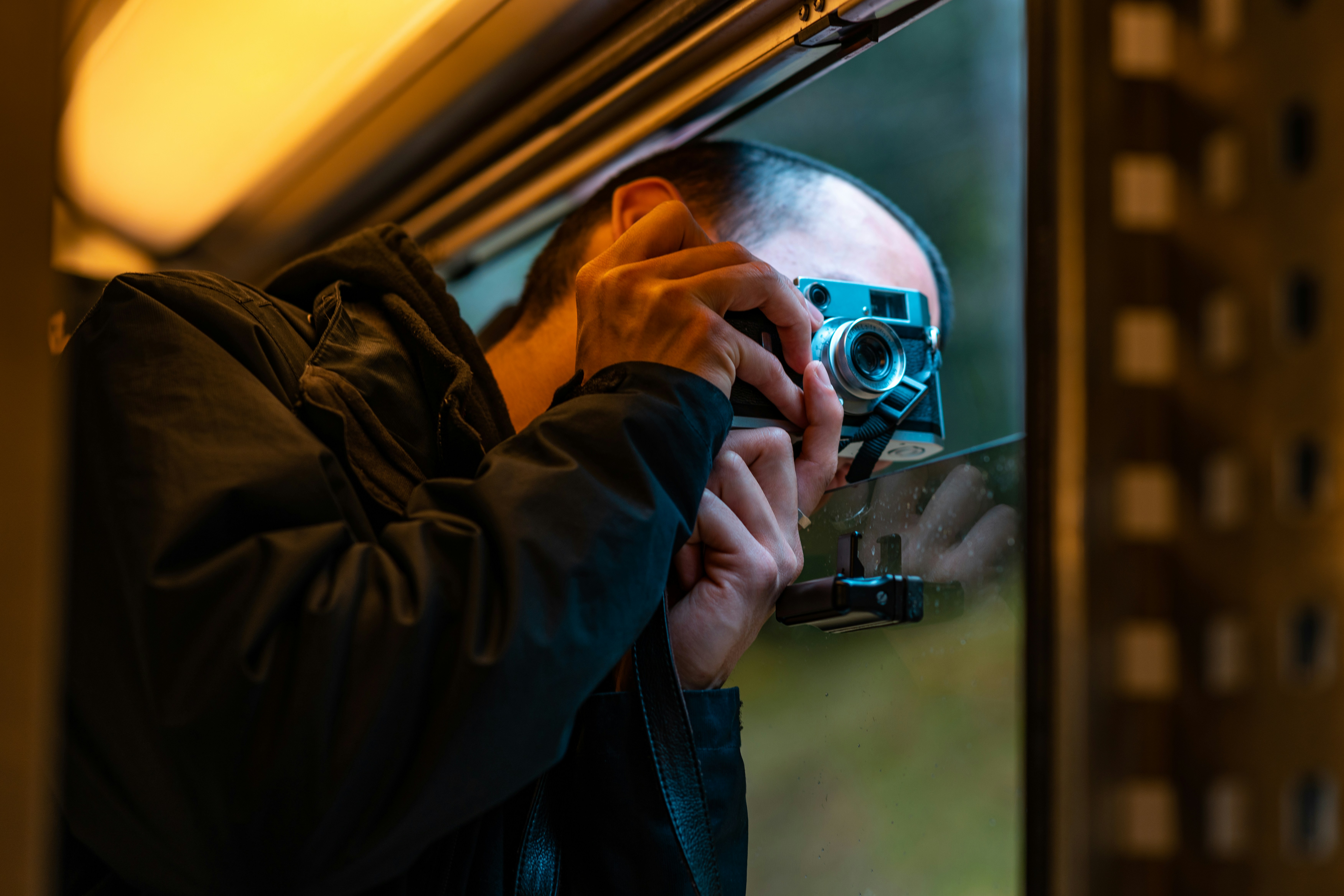 A man is taking a photograph with a camera.