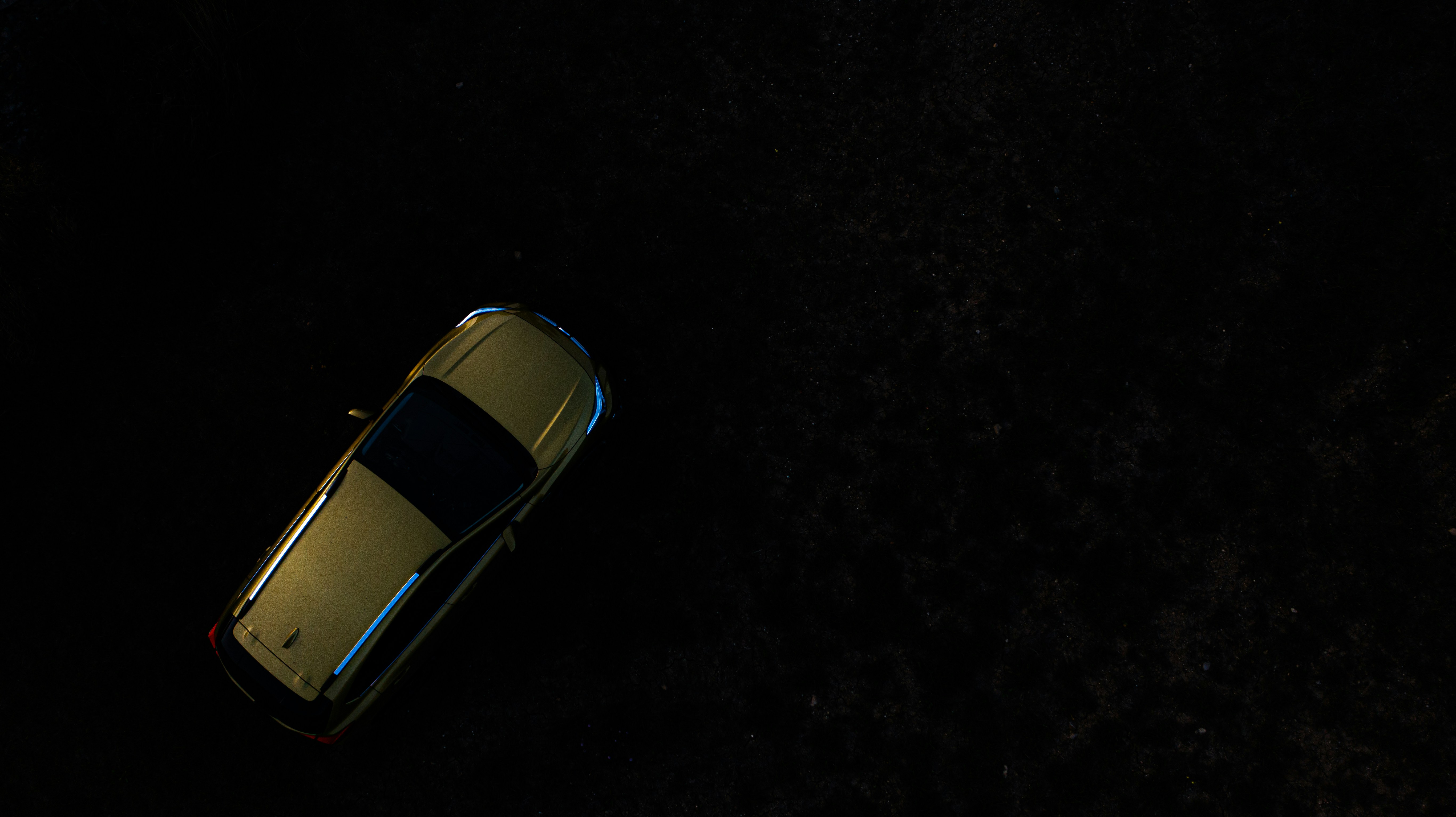 A futuristic autonomous electric car driving on a city street at night.