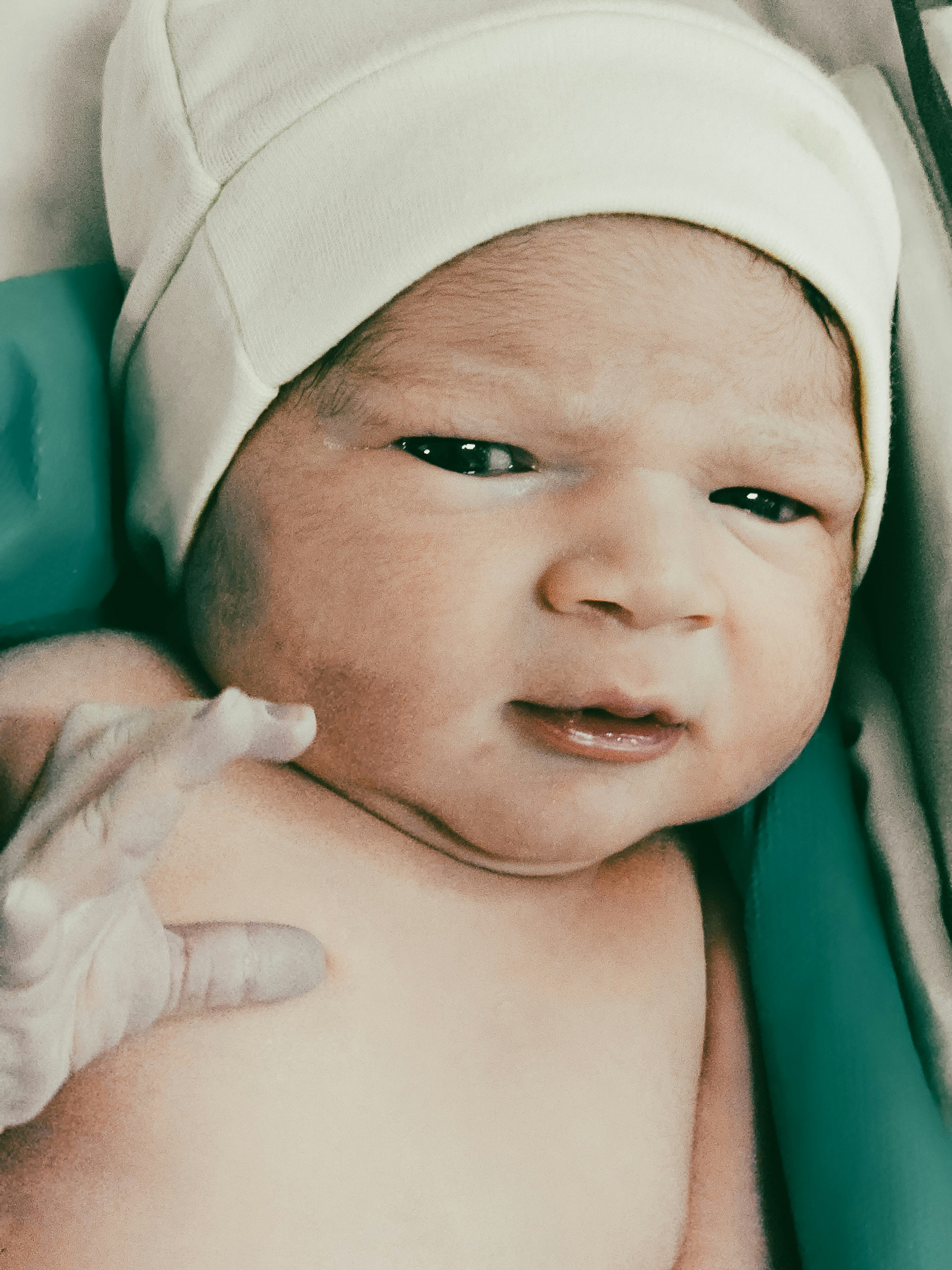 A newborn baby is staring at the camera.