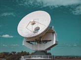 Large satellite dish against a blue sky.