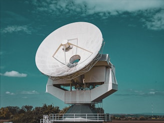 Large satellite dish against a blue sky.