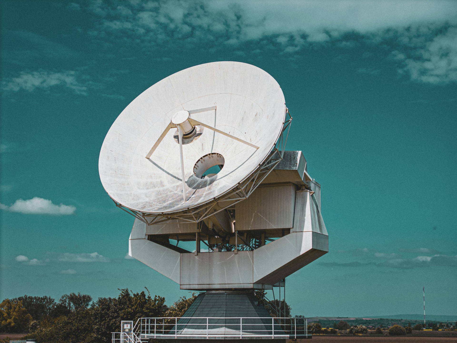 Large satellite dish against a blue sky.