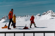 A family walks with sleds in a snowy landscape.