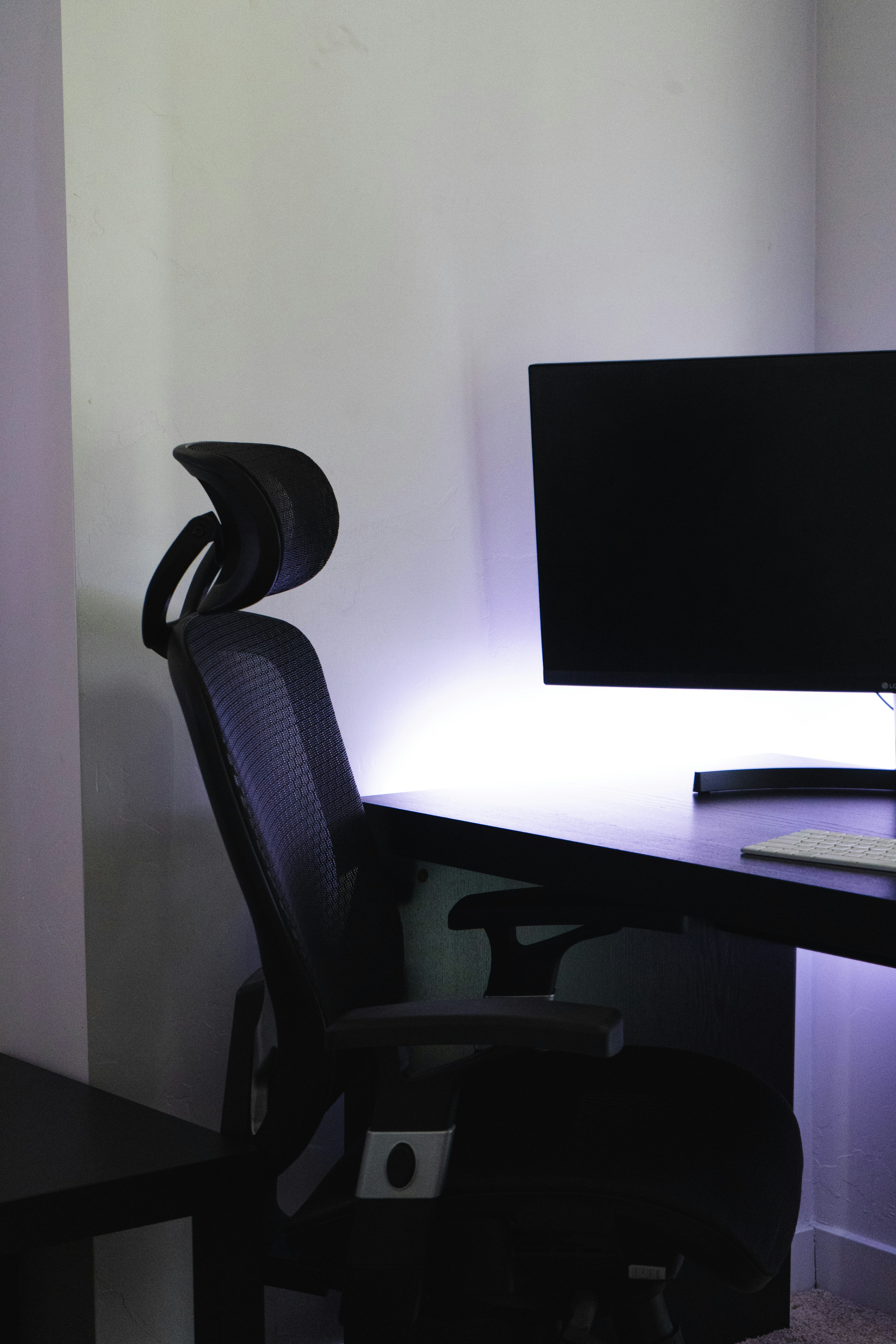 An office chair sits near a computer monitor.