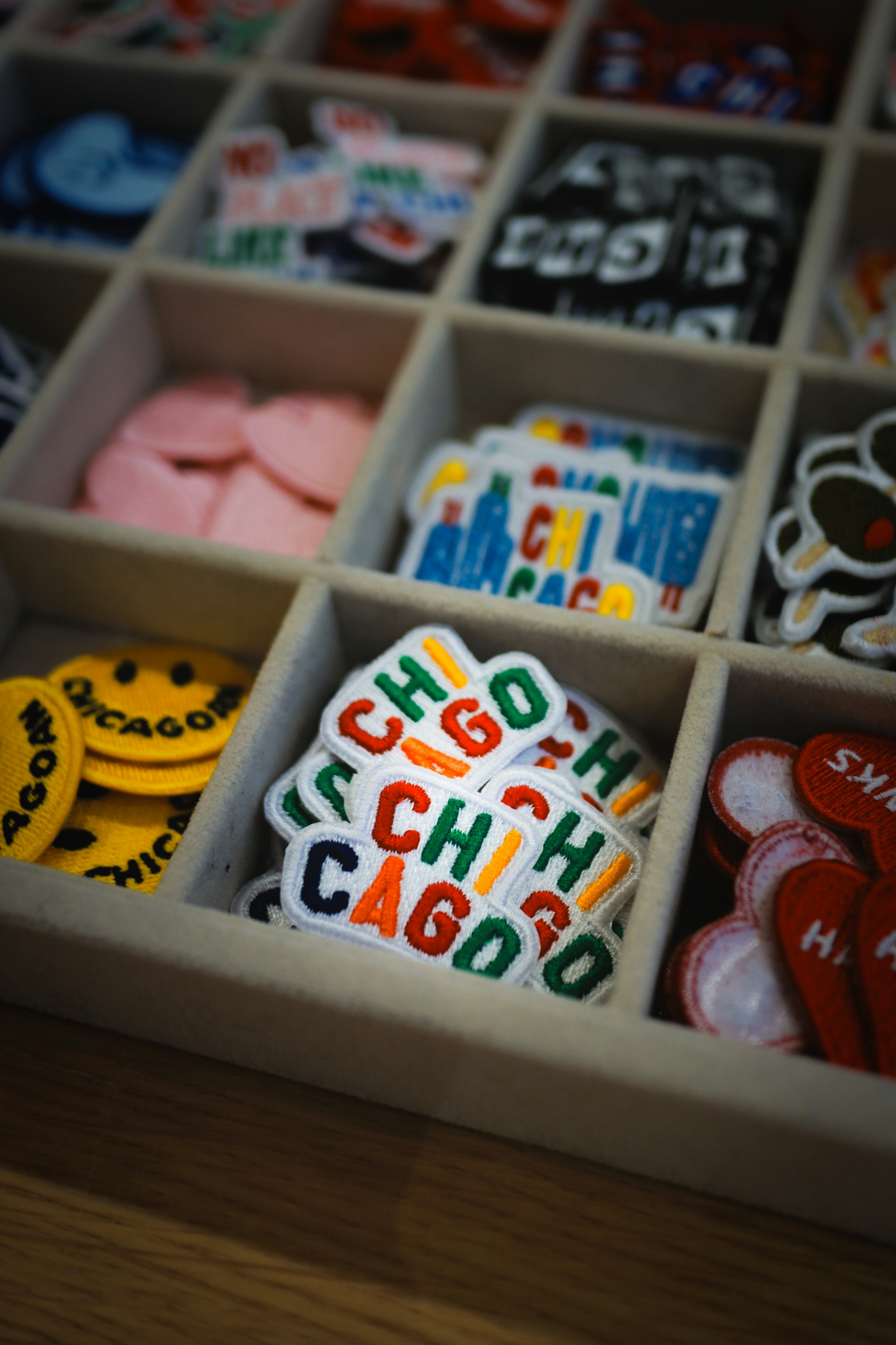 A tray displays various colorful patches and emblems.