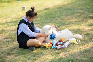 Woman pets a fluffy dog surrounded by toys.