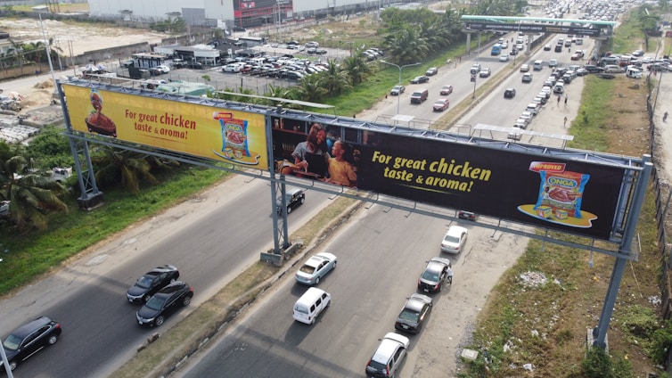 Billboard advertisements are seen over a busy highway.