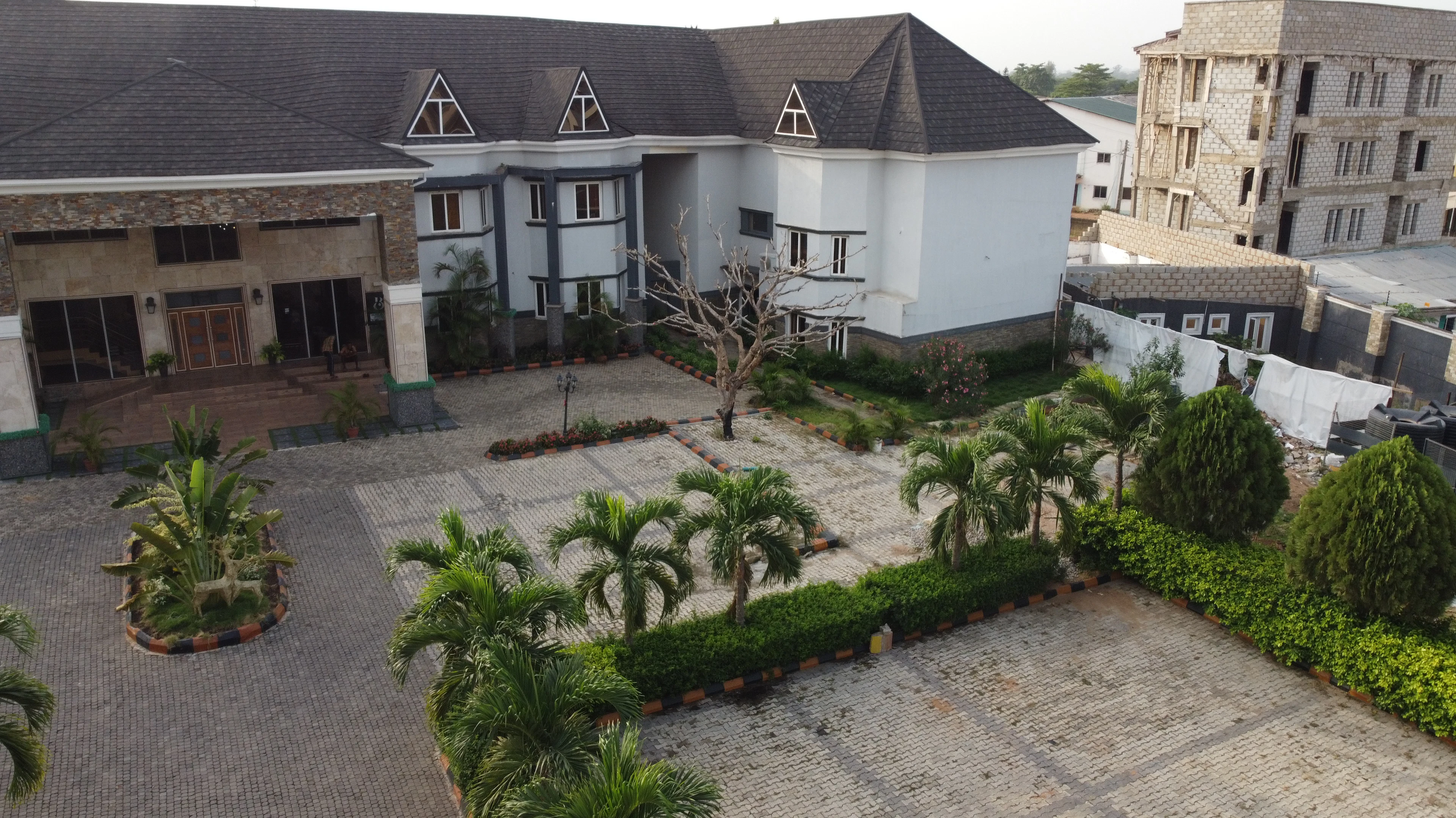Estate buildings with palm trees and a paved courtyard