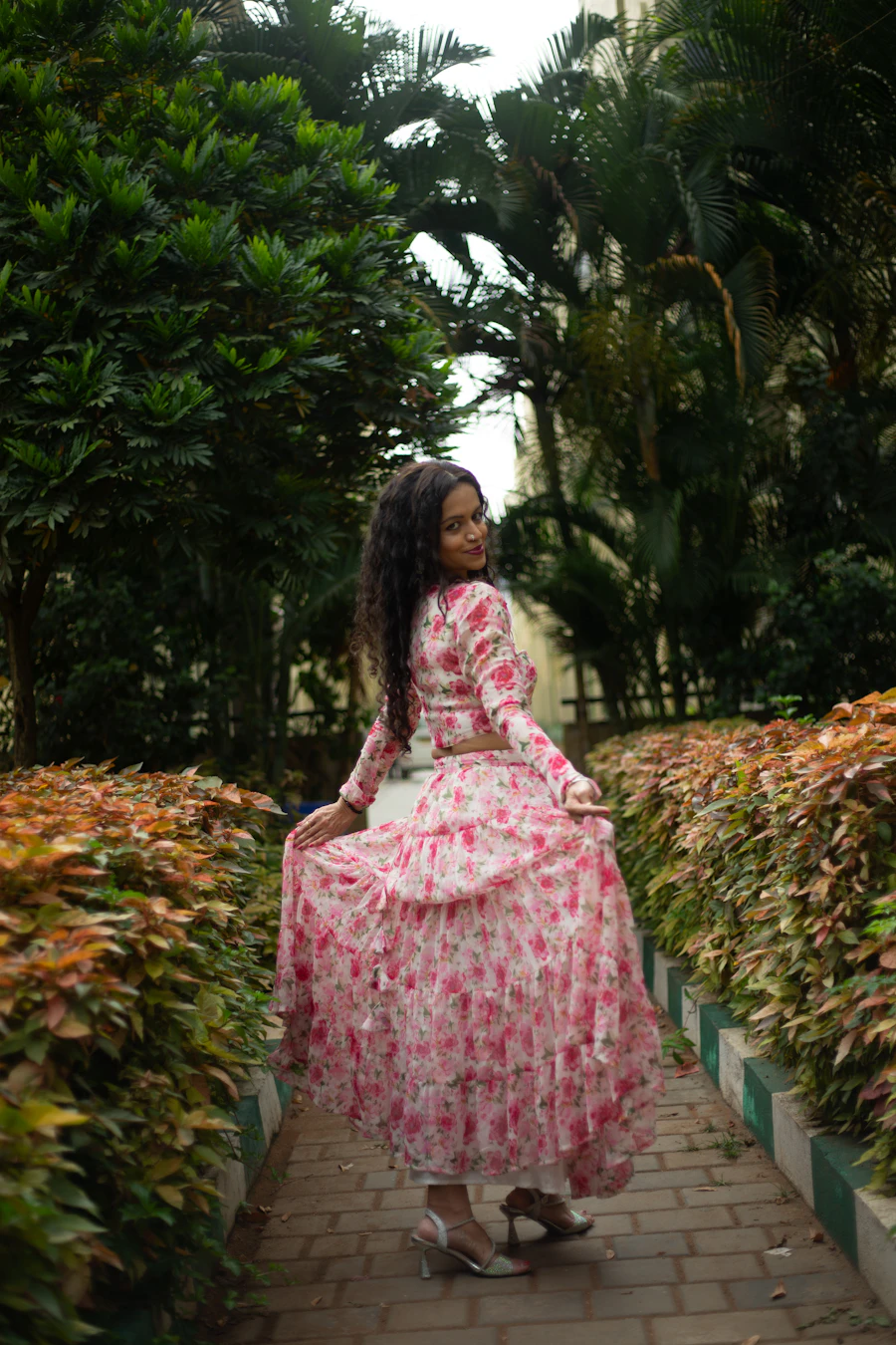 Woman walking through a garden in a flowing floral dress