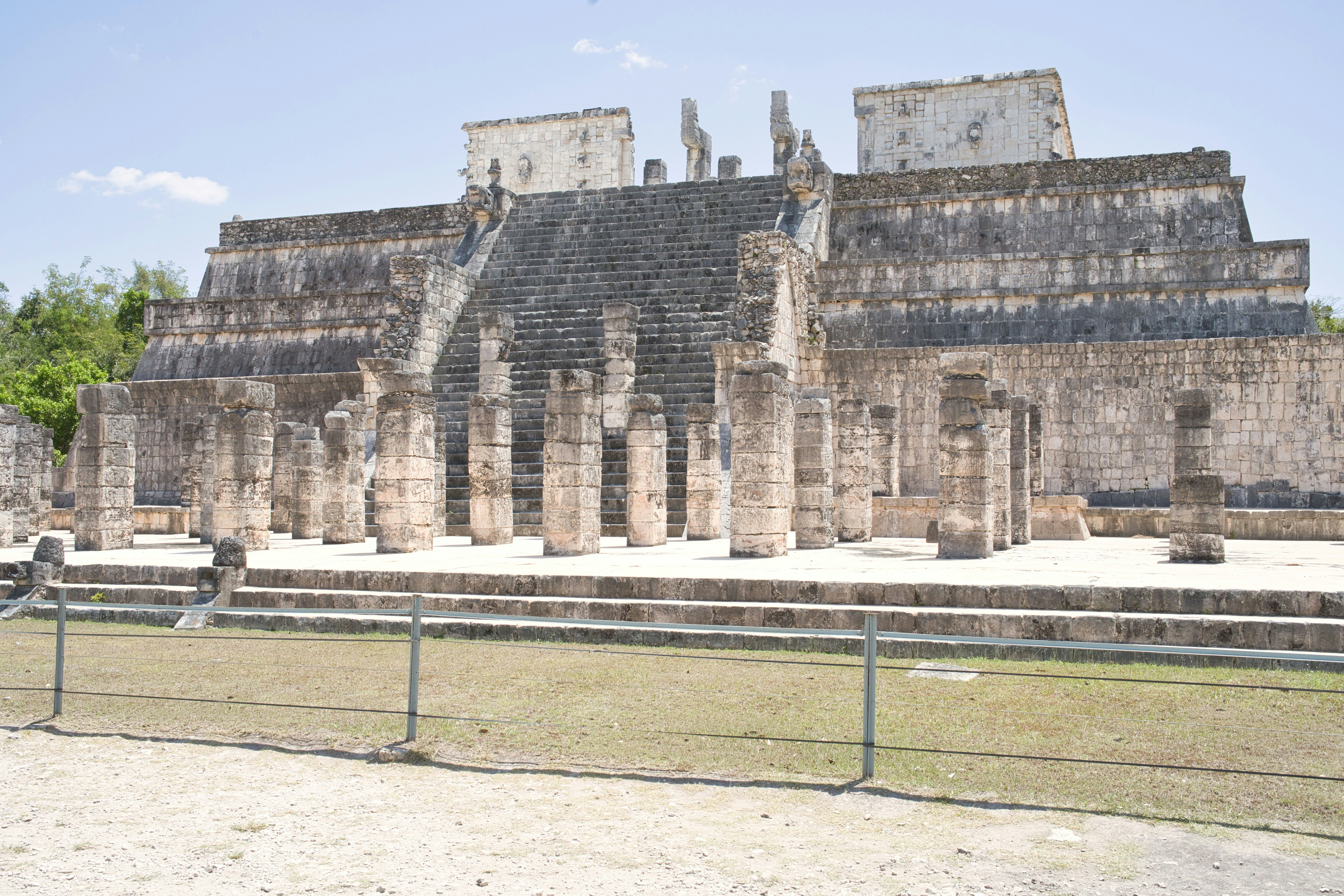 Ancient mayan ruins stand in the bright sunlight.