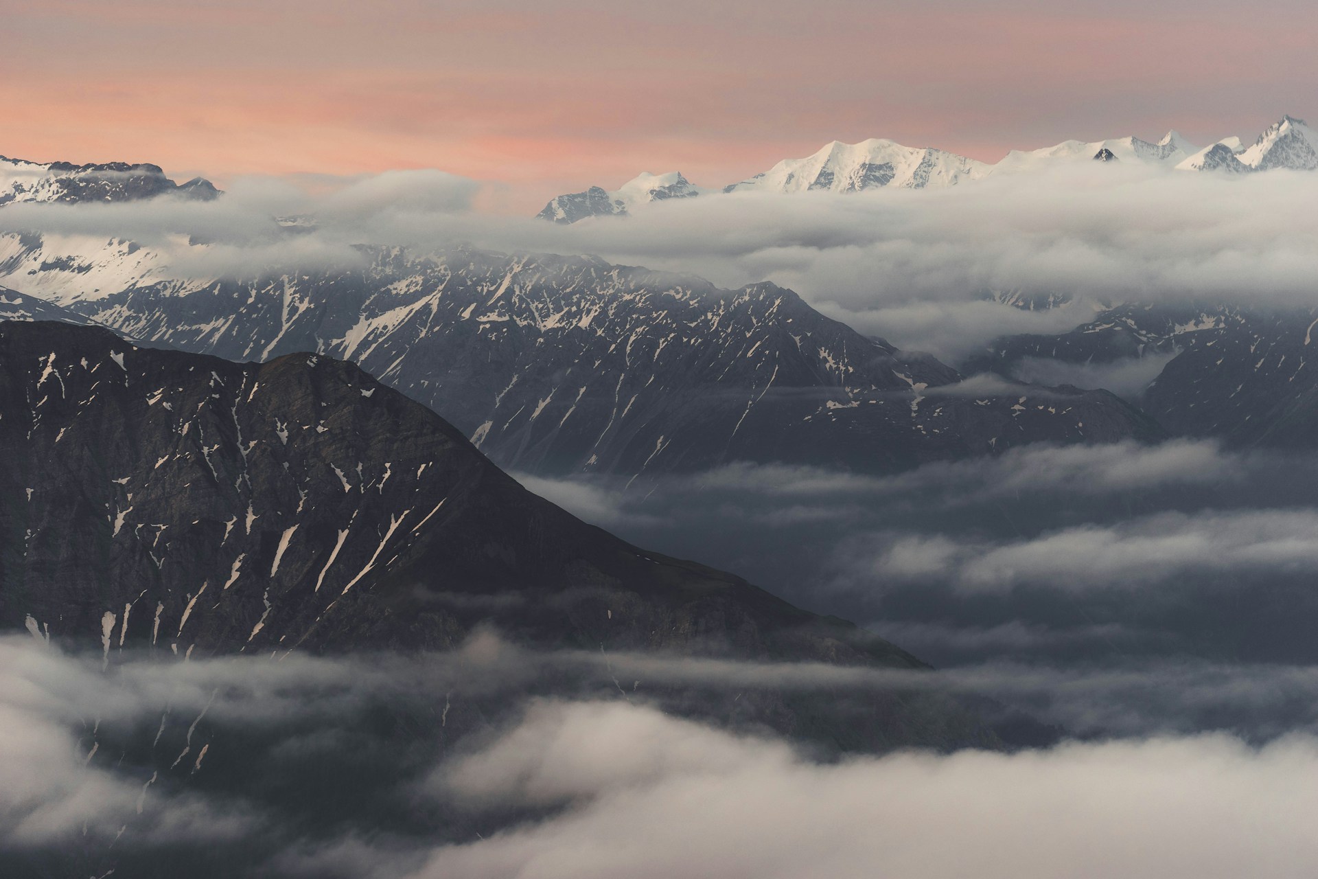 Mountains are shrouded in clouds at sunset.