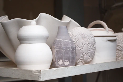 White ceramic pots and vases are neatly arranged.