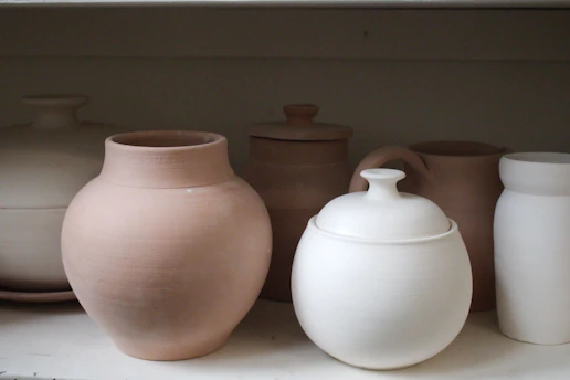 Ceramic pottery is displayed on a shelf.