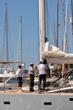 People working on the mast of a sailboat