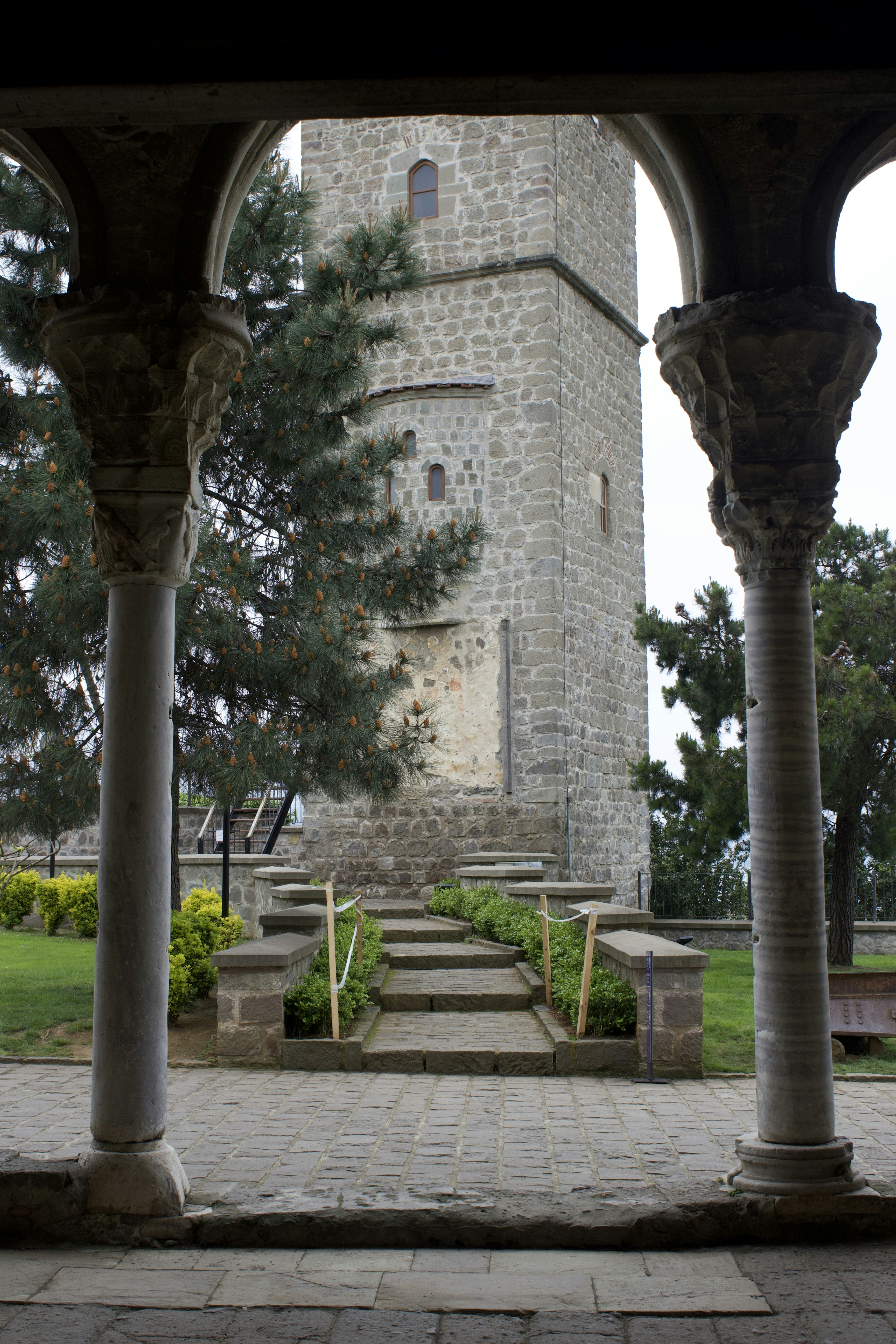 Stone tower framed by columns and arches.